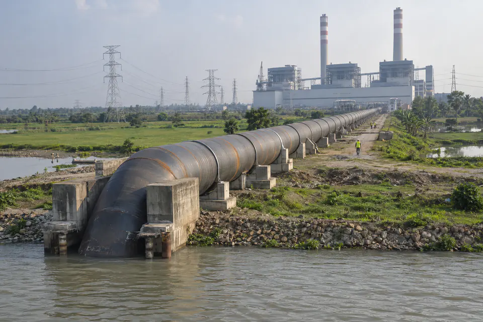 Illustration: a large spiral steel cooling water pipeline running from a river to a power station