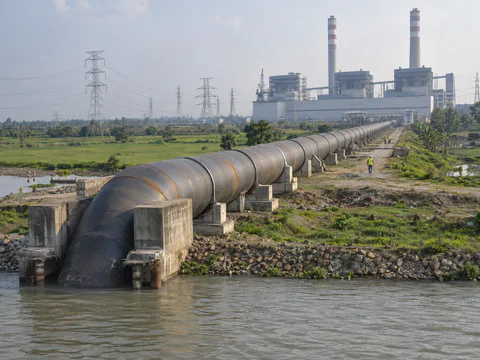 Illustration: a large spiral steel cooling water pipeline running from a river to a power station