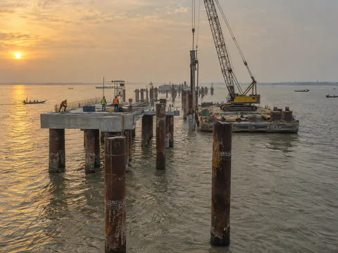 Illustration: steel pipe piles forming a jetty in a tidal river estuary