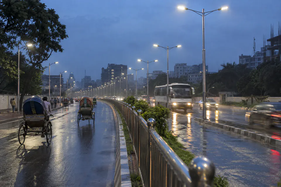 Illustration: steel street light poles and a stainless steel railing on a city road at dusk