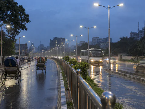 Illustration: steel street light poles and a stainless steel railing on a city road at dusk