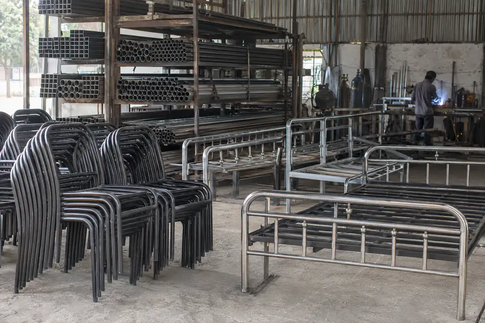 Illustration: steel tube chair frames and bed frames in a furniture workshop
